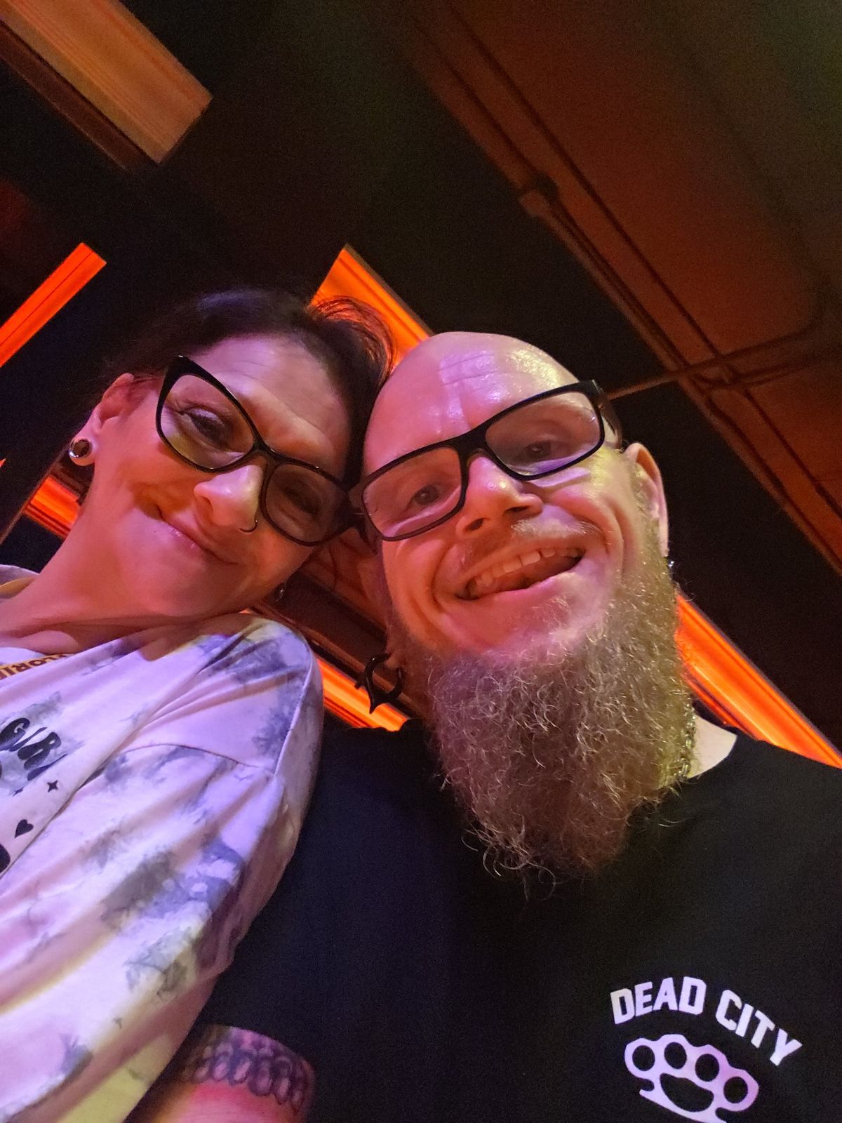 Tank and Sandra smiling together in warm red light